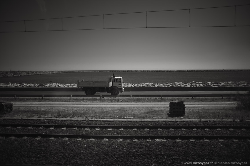 Le train qui regarde les camions qui passent